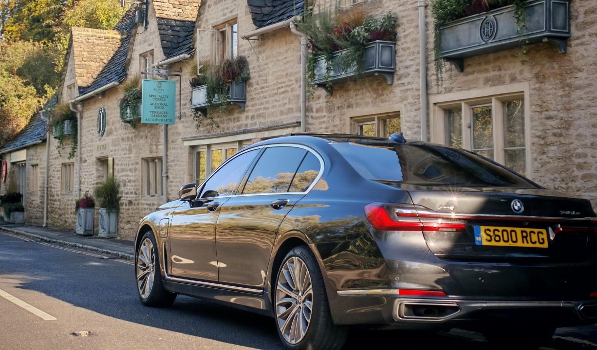 A black luxury BMX car parked in front of a cafe