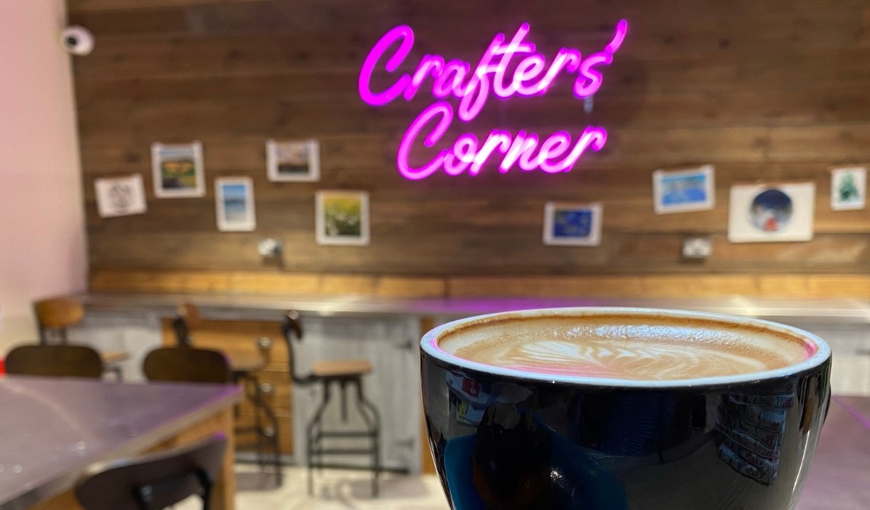 Crafter's Corner neon sign, coffee in front