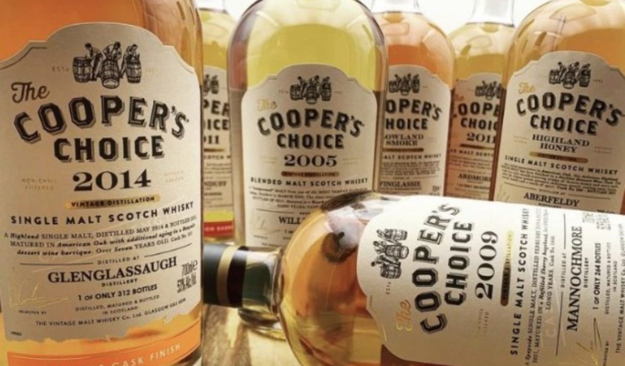 A selection of whisky bottles with brightly coloured labels from different distilleries on a white background.