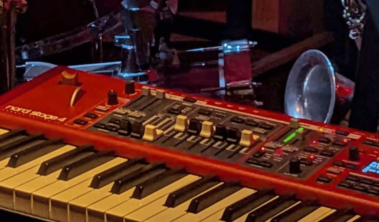A photo of a saxophone, drum, and keyboard. The Sparkfest logo in the top corner