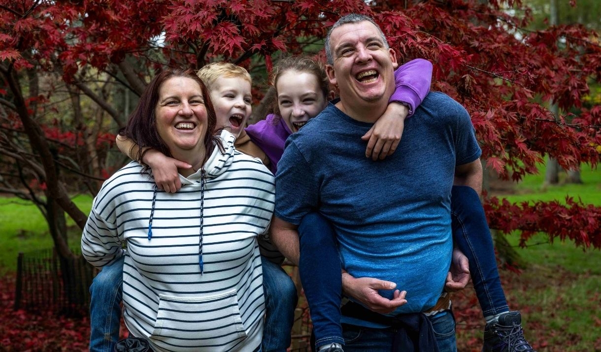 family of four in autumn woodland