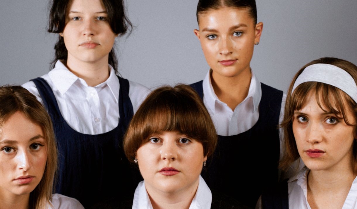 Five young women dressed in young nun outfits stare directly. The Sparkfest logo is at the top corner