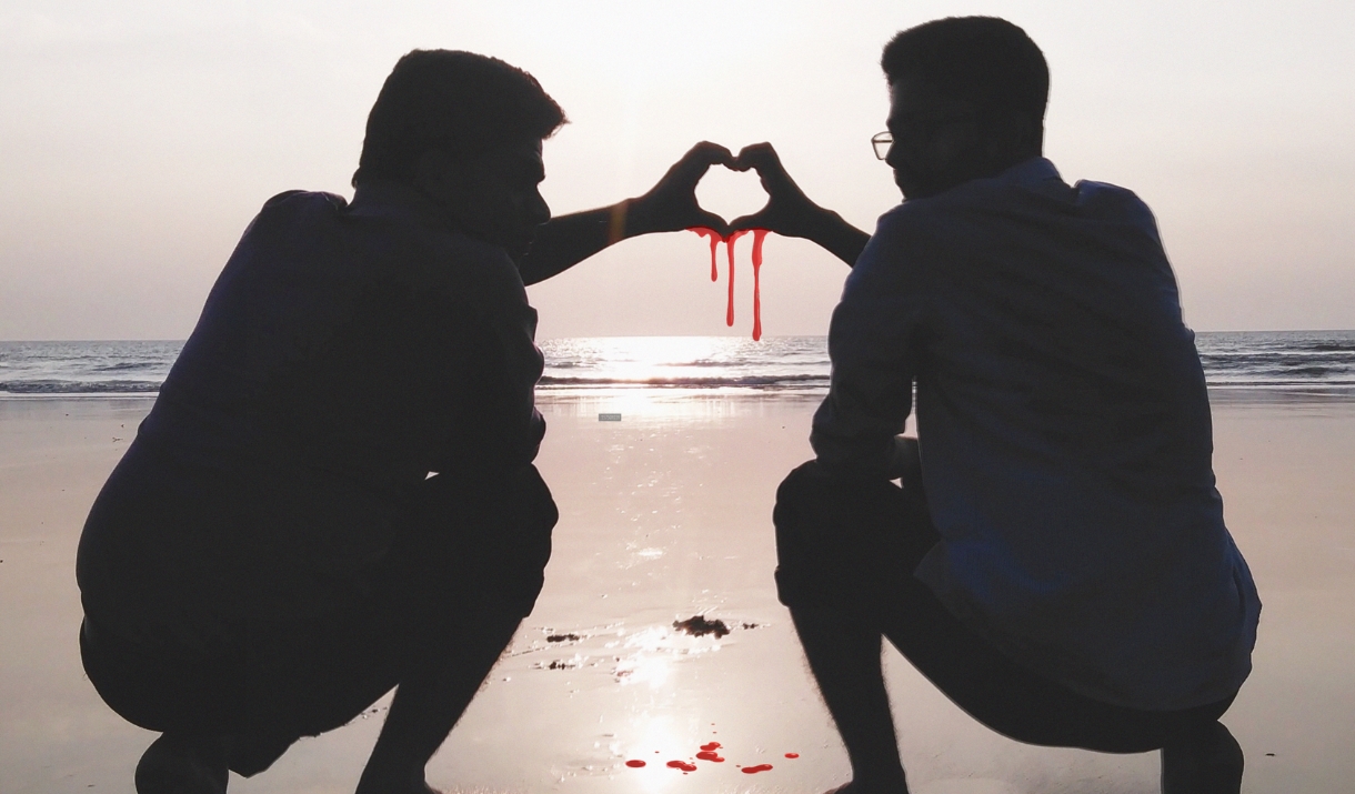 Two brothers making a 'hand heart' which is dripping blood