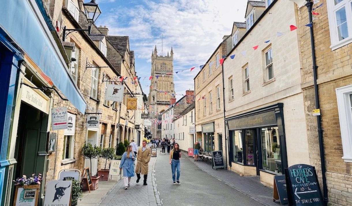 A street in Cirencester with bunting overhead and the Parish of Cirencester behind