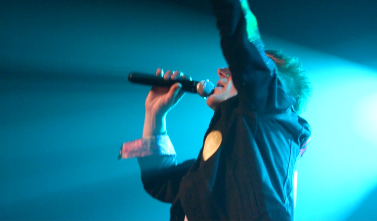 A photo of the singer for Tribute Triple Bill singing into a microphone