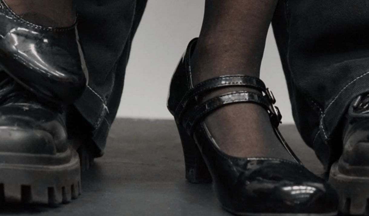 Two pairs of black formal shoes stumble over one another. Sparkfest logo in top corner