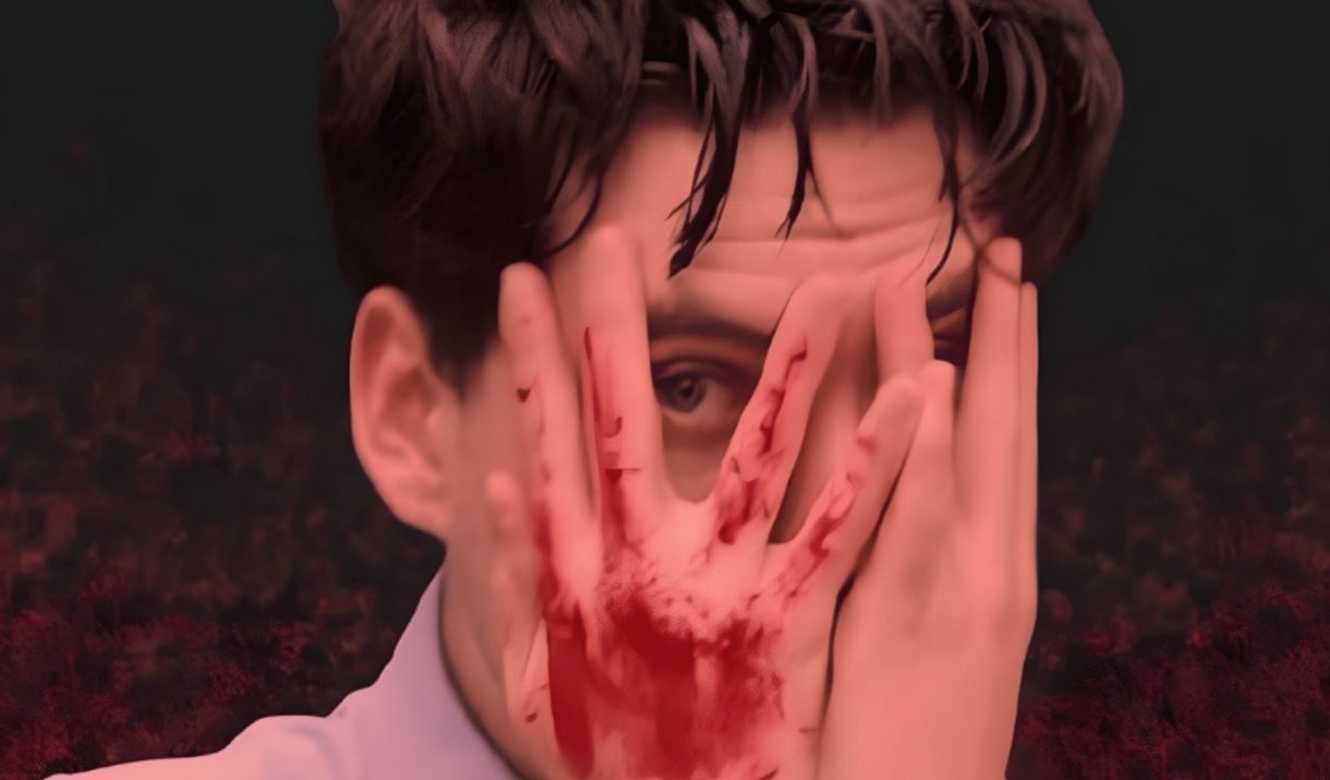 A young man is semi covering his face with his hands, eye peeping between fingers in terror; the back of one of the hands is slashed in blood. Sparkfe