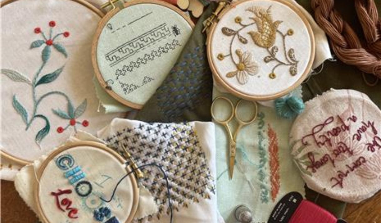 a selection of embroidery hoops and threads on a table, showing a range of embroidery techniques