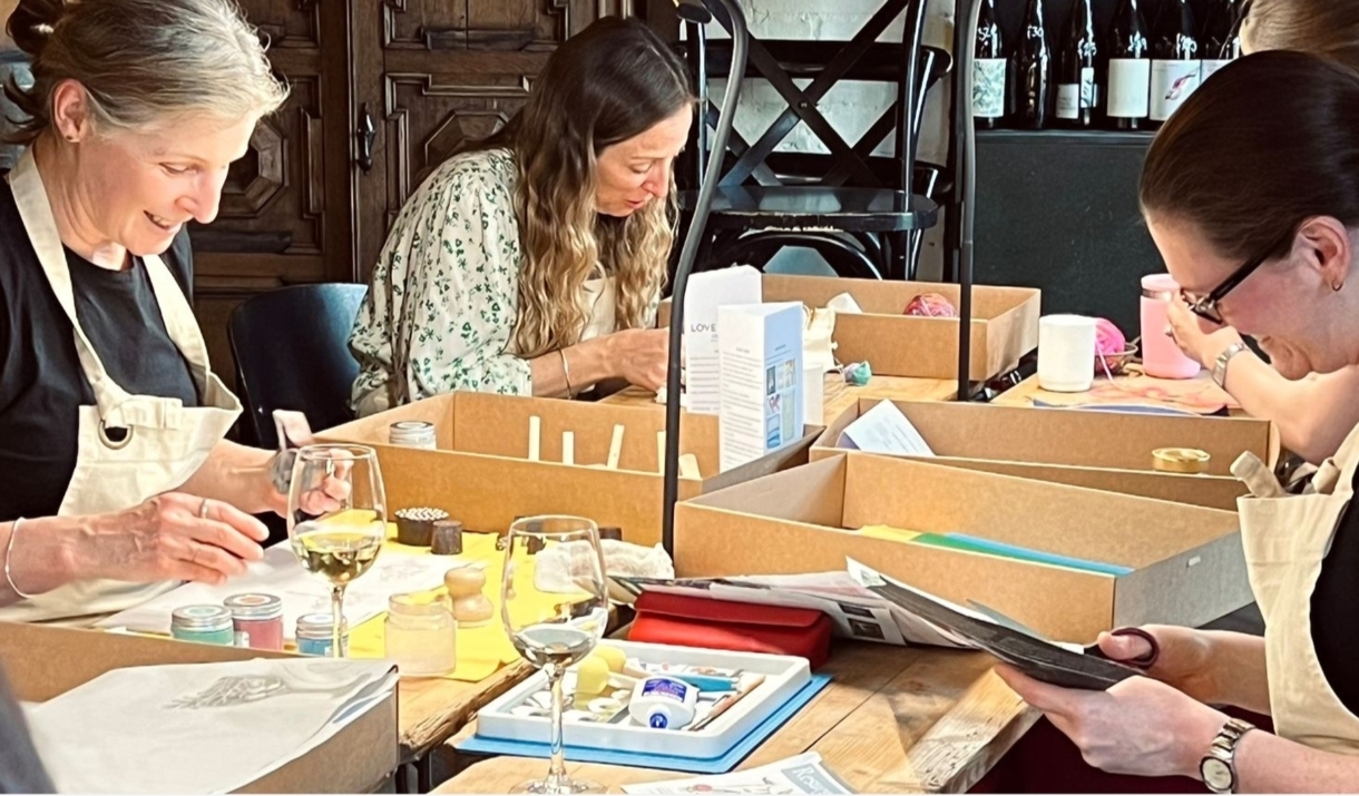A group of ladies sat at a table crafting