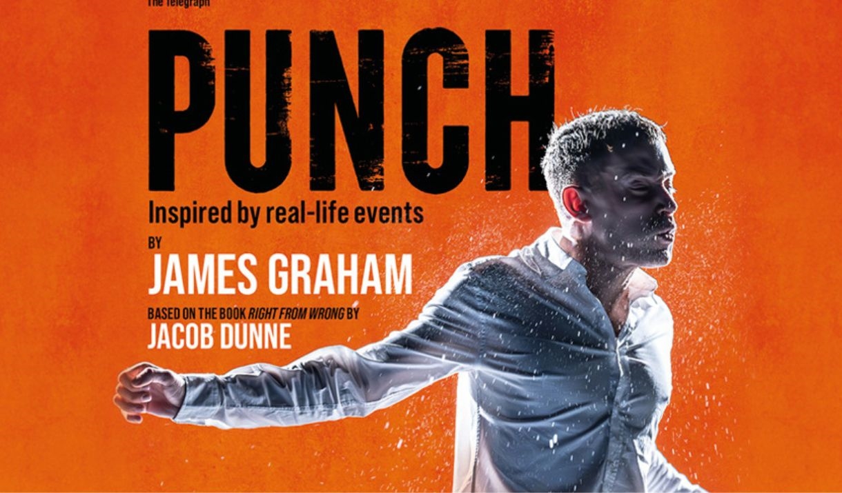 A man stands in front of an orange background, being punched in the face.