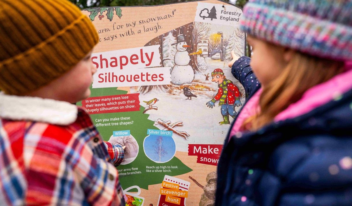 two children look at colourful Stick Man trail panel