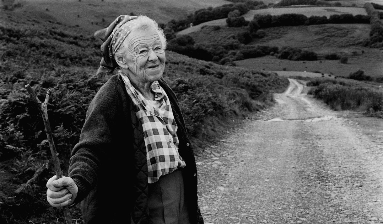 Black and white photograph of an elderly woman with a walking stick