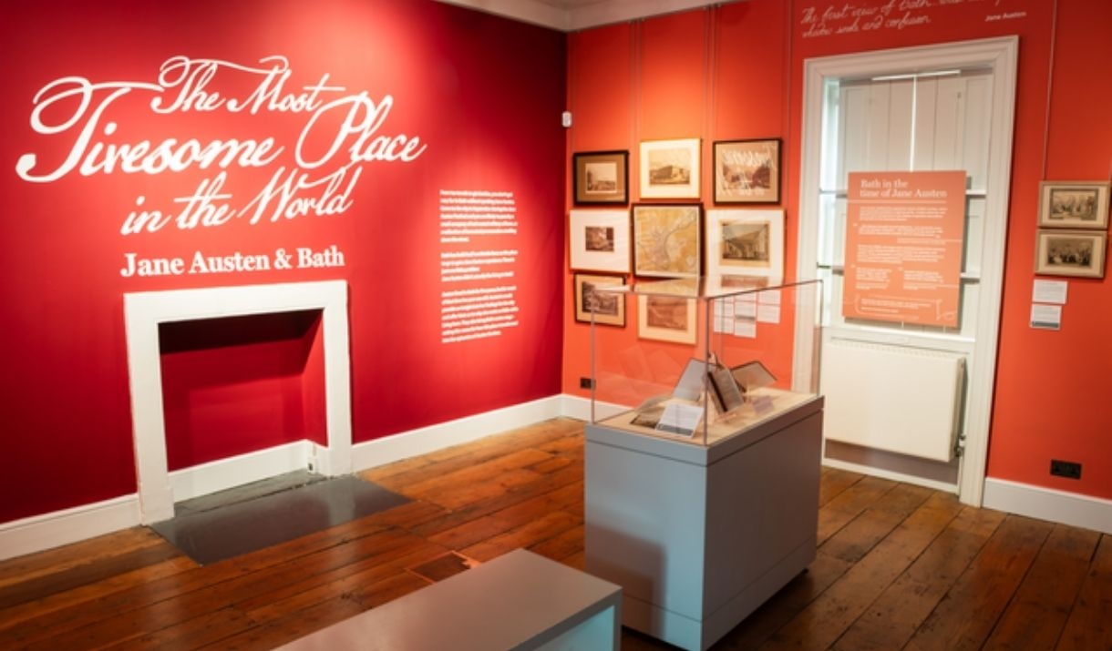 Exhibition room with red walls and white writing