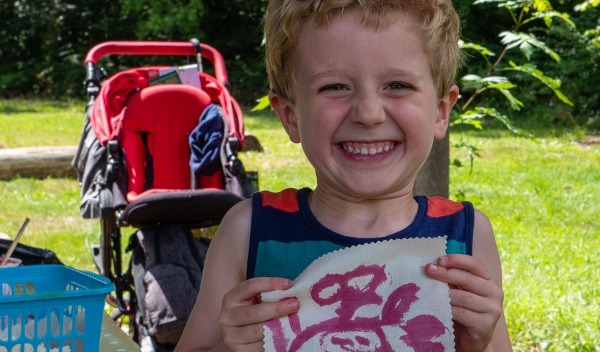 child holds up hand painting outdoors