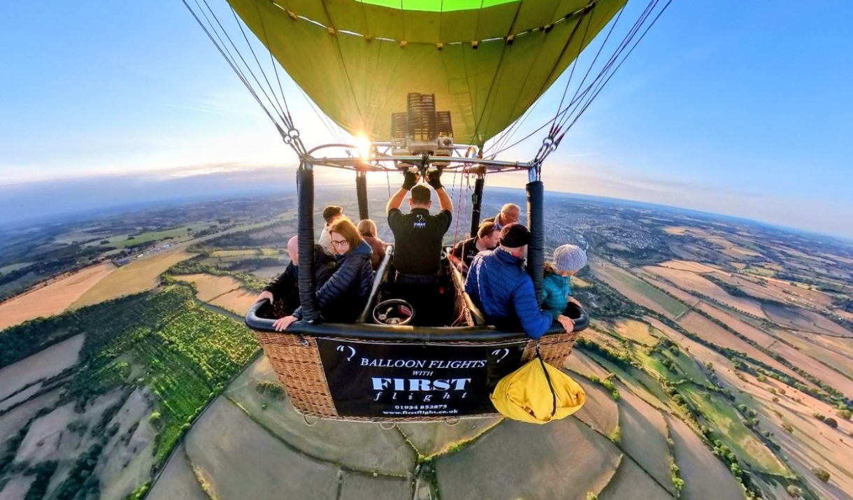 View of people in a balloon basket in the whilst in the air.