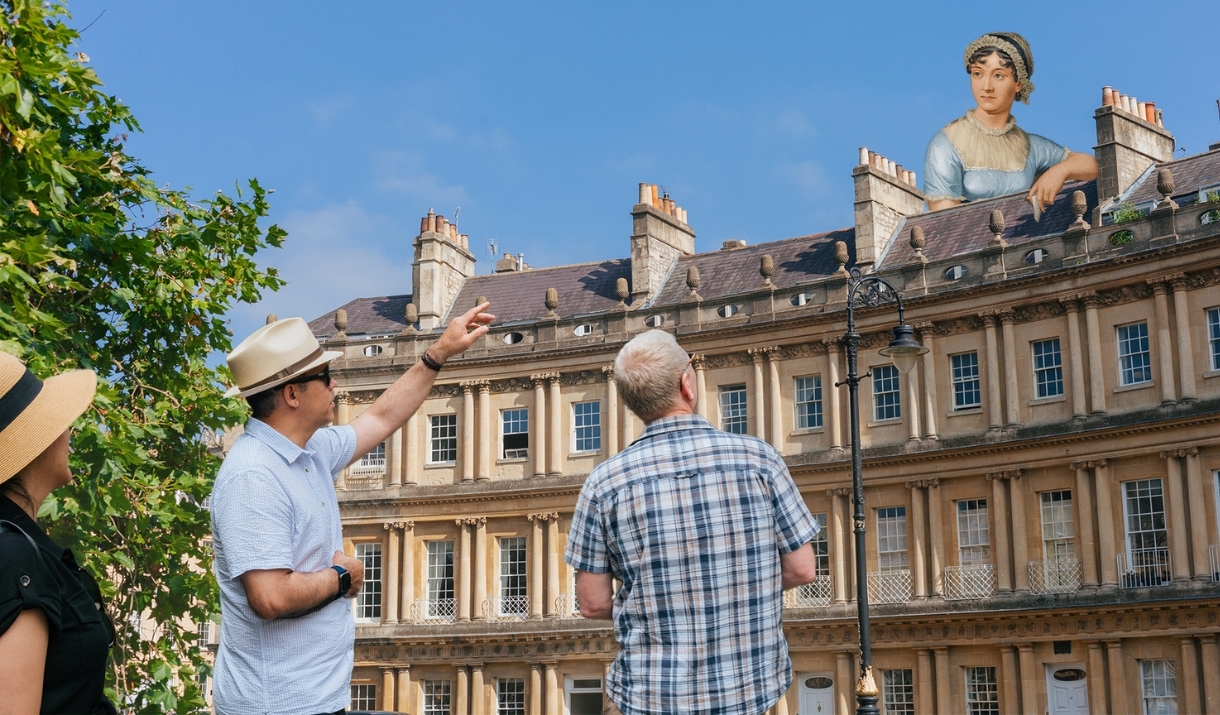 Tour guide discussing Jane Austen standing above and behind Bath architecture