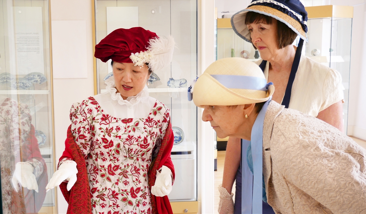 3 ladies dressed in regency wear