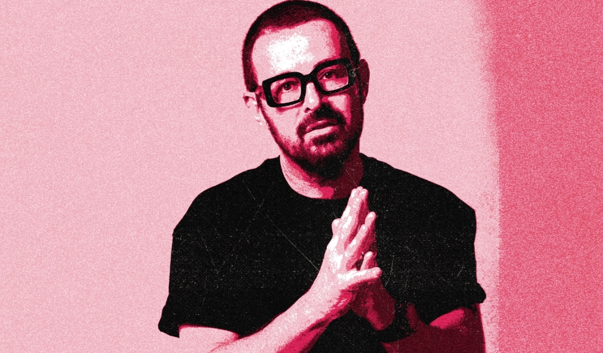 DJ Judge Jules stands with his hands together in front of his chest