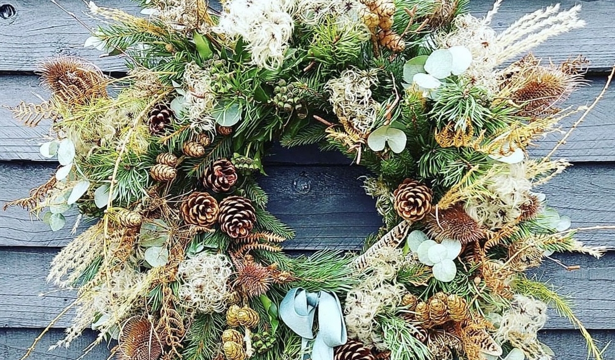 A festive wreath against a blue panelled wall