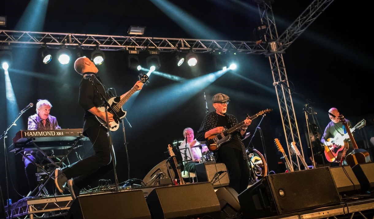 Two men with guitars on a stage