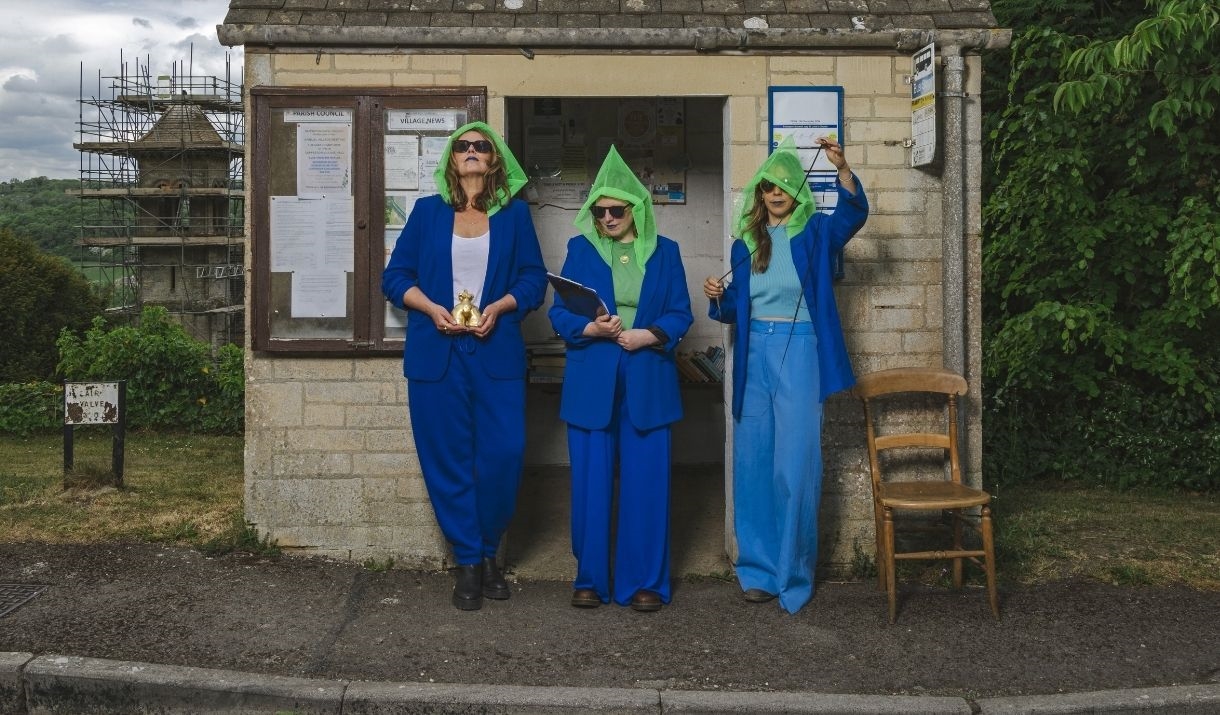 three women standing in a bus shelter