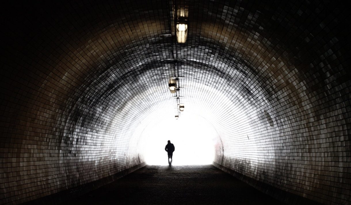 An unsettling large tunnel, with a shadowy man at the end of it.