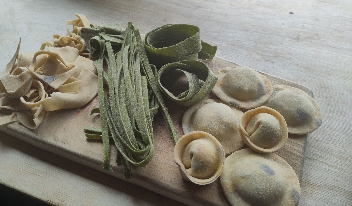 different types of pasta on a wood board