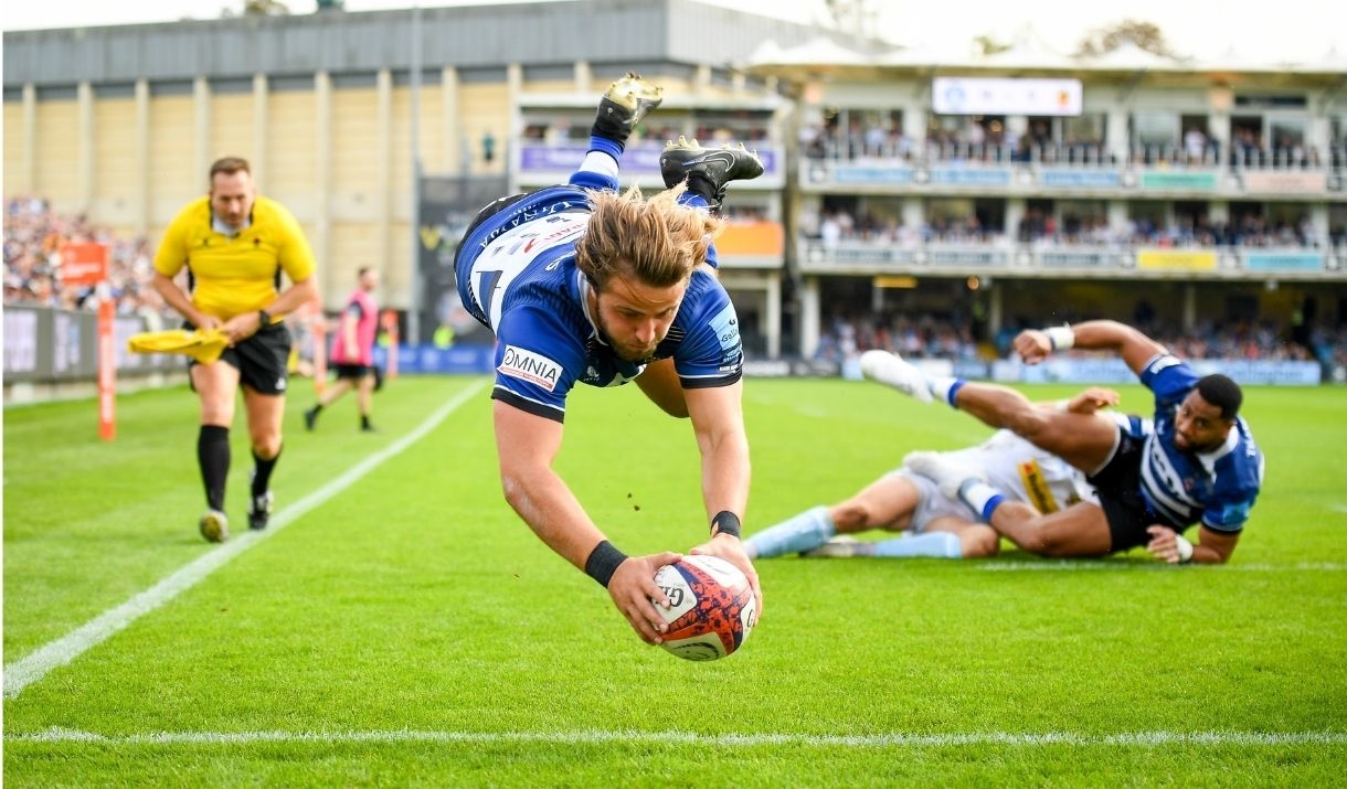a man diving with a rugby ball