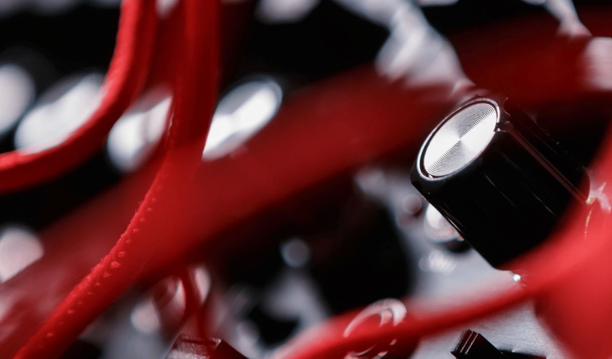A tangle of red wires across a music sound board