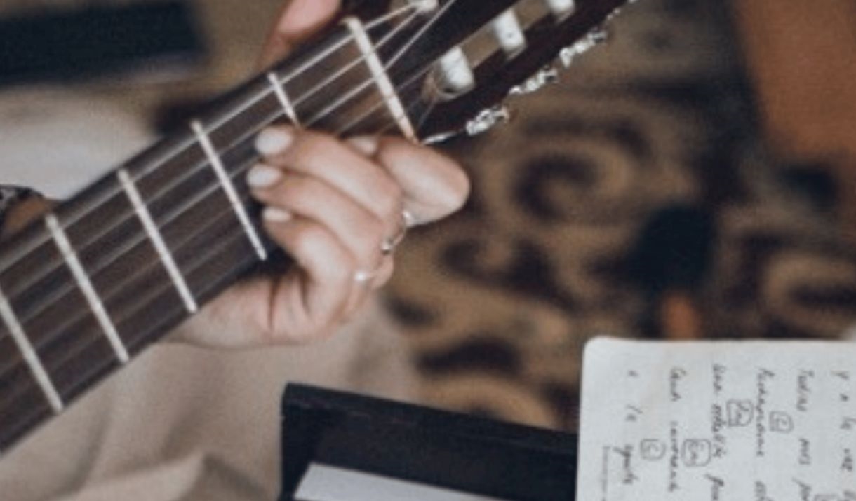 someone playing a guitar with a keyboard in front. Sparkfest logo in the top corner