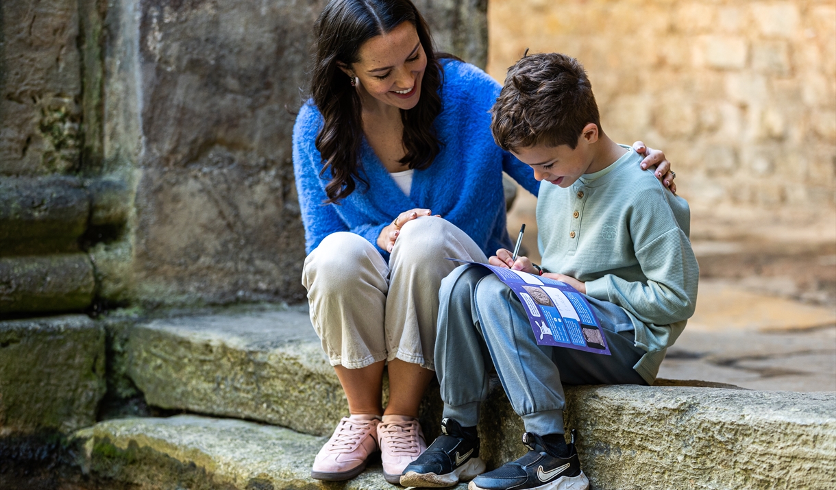 a woman and boy looking a paper trail