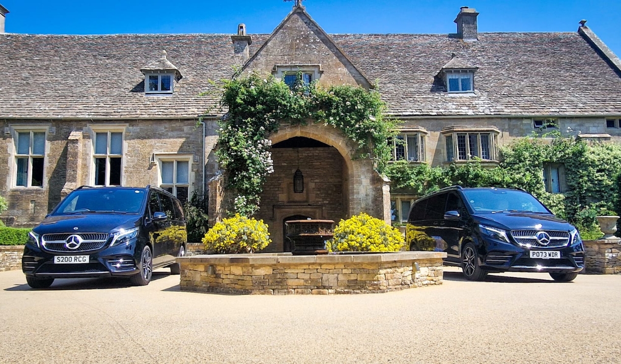 Two black Mercedes vehicles parked in front of the entrance to Coombe End Manor