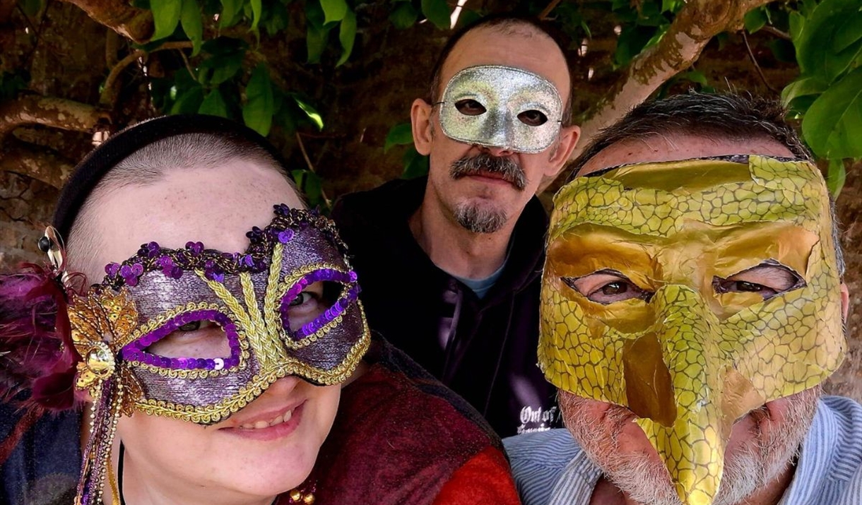 three people in fancy masks