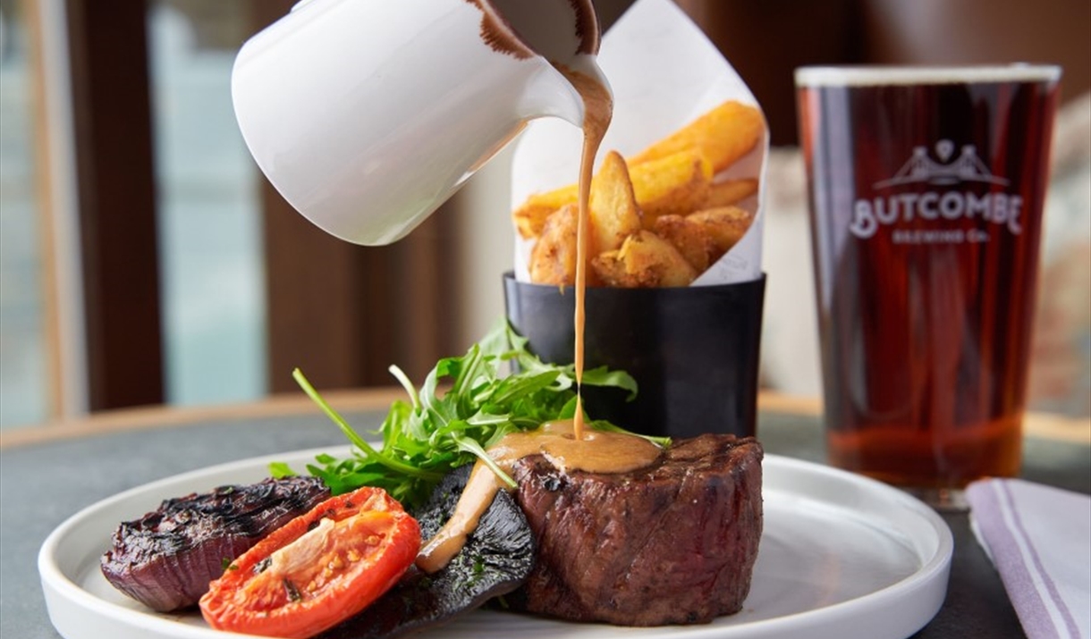 Sauce being poured over steak