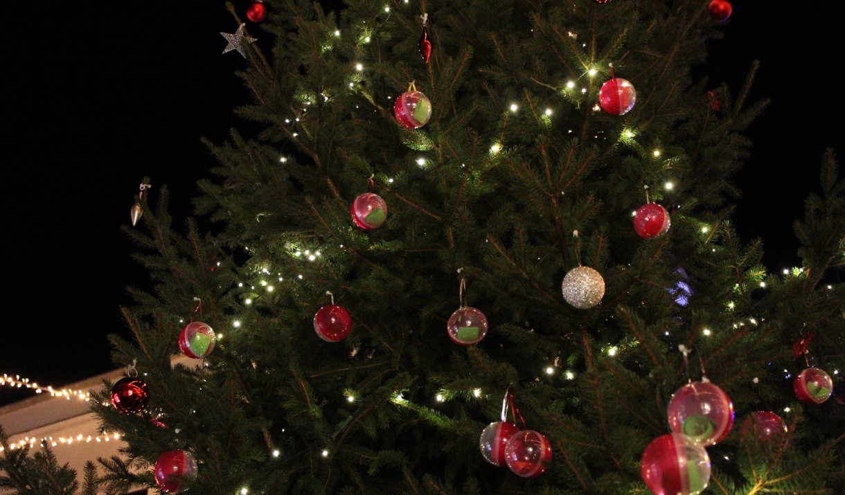 A Christmas tree with red and green baubles and twinkly lights.