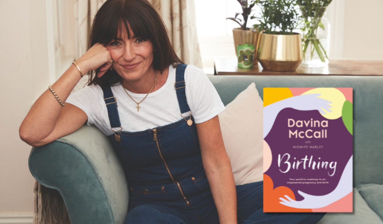 Davina McCall smiling next to her book