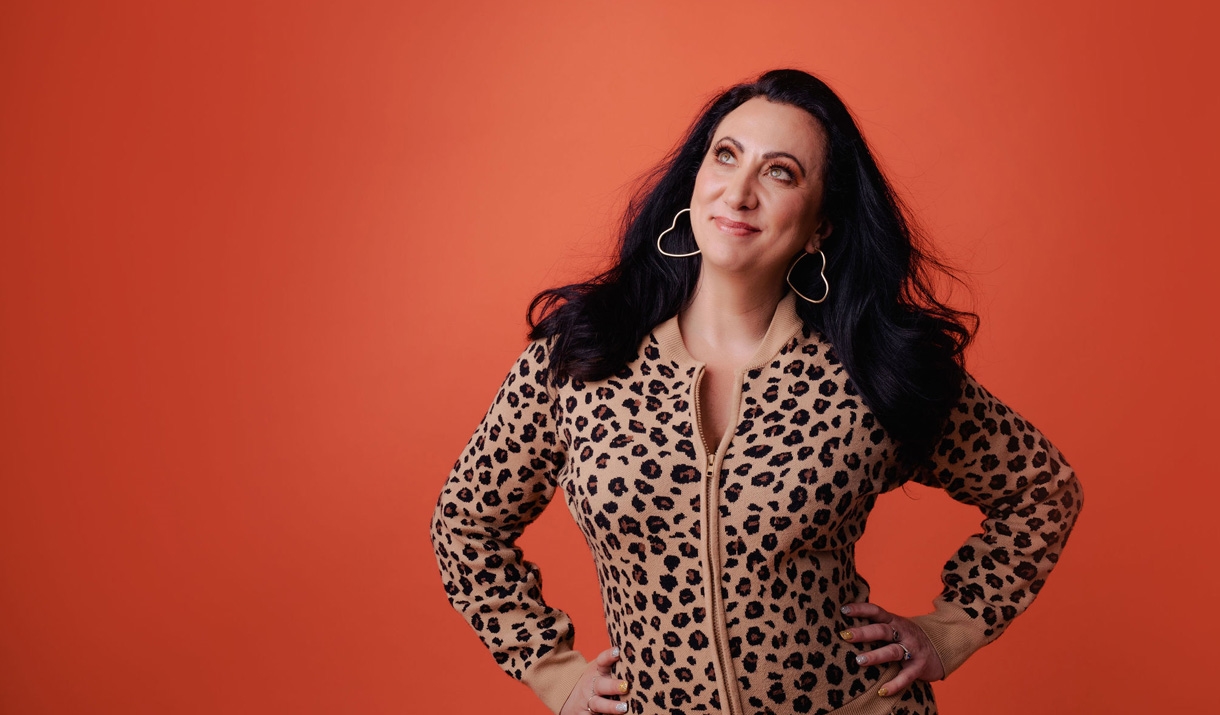 Woman with long brown hair wearing leopard print