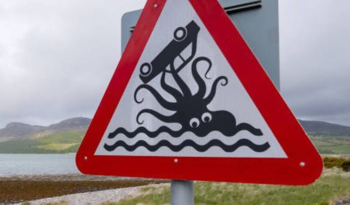 A comical road sign of a car being taken by a kracken on the west coast of scotland.