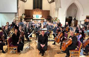 Photo of the orchestra with conductor in front