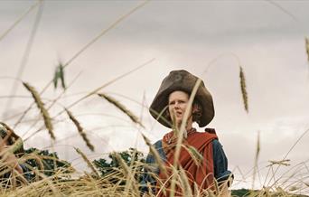 Still from film of a woman in a field