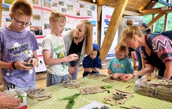 family completing craft activity around a table indoors