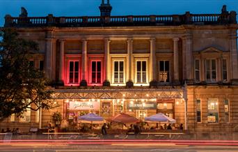 Exterior view of Green Park Brasserie and Bath Pizza Co by night.