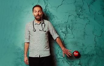 Benj Waterhouse wearing a stethoscope and pressing a panic button