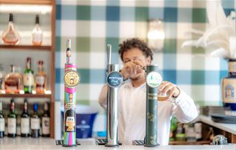 Image of person pouring a pint behind the bar