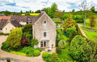 Dovecote Cottage's exterior surrounded by nature and forestry.