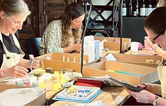 A group of ladies sat at a table crafting