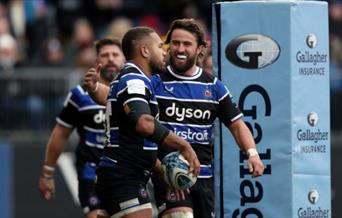 Ollie Lawrence of Bath Rugby celebrates his try against Saracens with teammate Tom de Glanville.