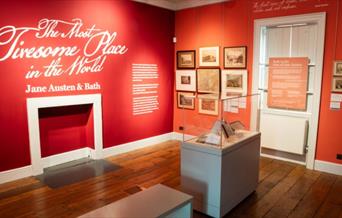 Exhibition room with red walls and white writing