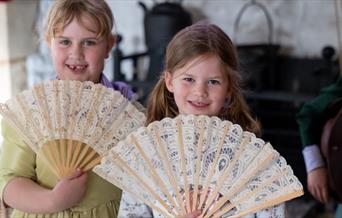 Two girls holding fans