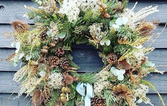 A festive wreath against a blue panelled wall